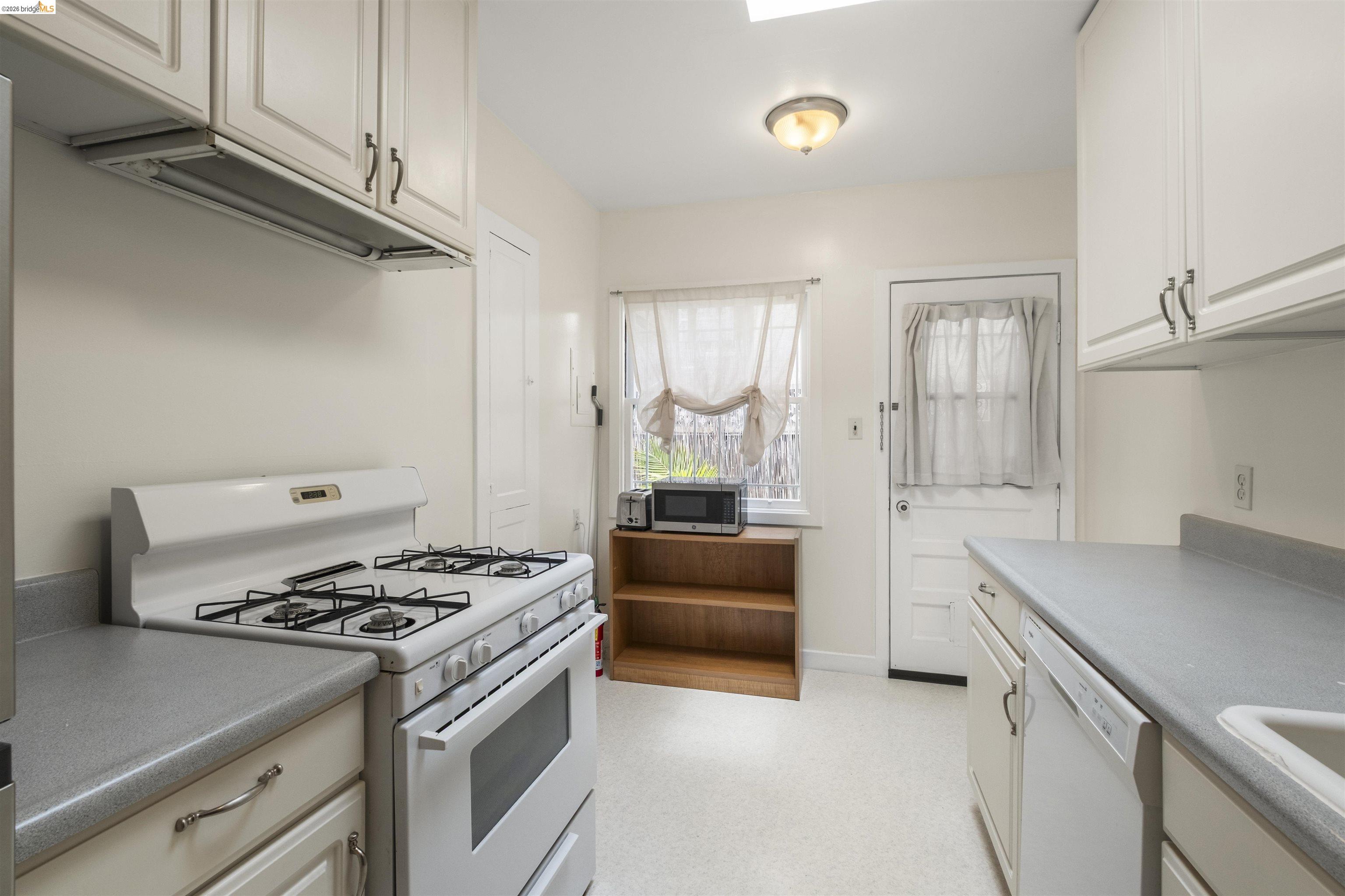 2444 Virginia Street, Unit B Berkeley, CA 94709 - Photo 23 of 39 Kitchen featuring a white gas range, white cabinetry, and light-colored countertops