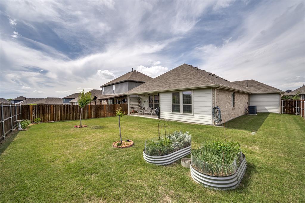 413 Wiggins Way Van Alstyne, TX 75495 - Photo 25 of 25 Spacious backyard featuring a manicured lawn, a full privacy fence, and a covered patio