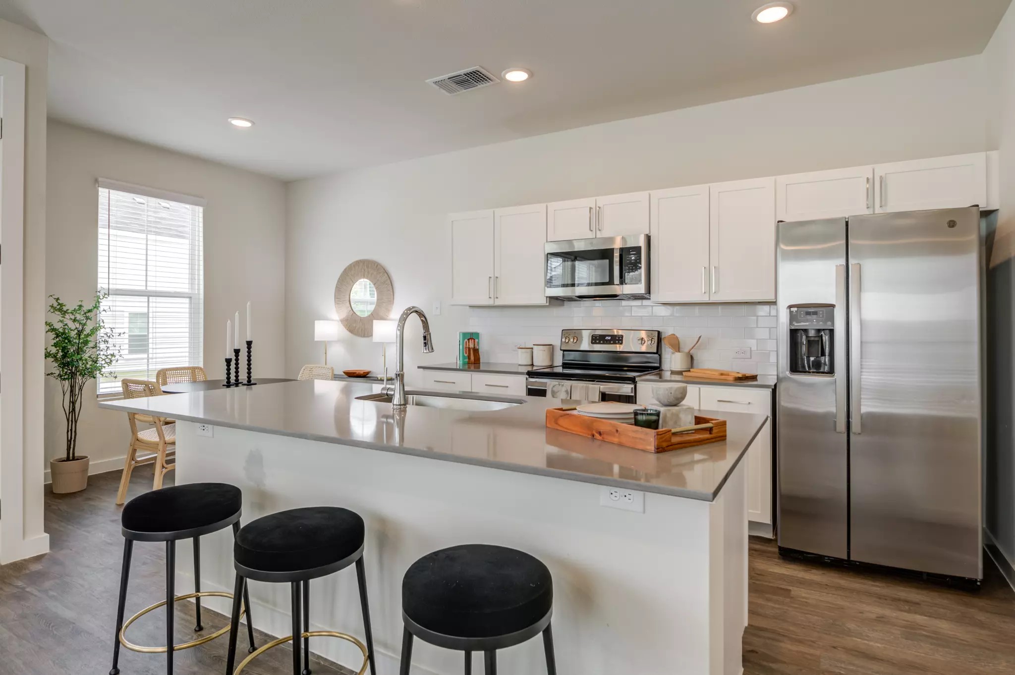 801 Bluestem Way, Unit 108S Cedar Hill, TX 75104 - Photo 5 of 9 a kitchen with stainless steel appliances granite countertop a sink a stove a refrigerator cabinets and a dining table with wooden floor