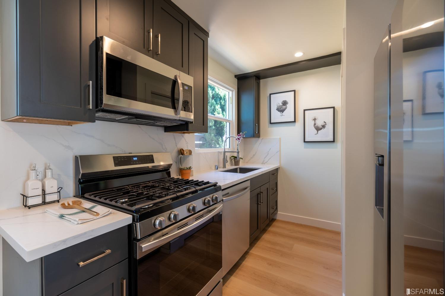 951 University Avenue Berkeley, CA 94710 - Photo 17 of 34 a kitchen with stainless steel appliances a stove a microwave and cabinets