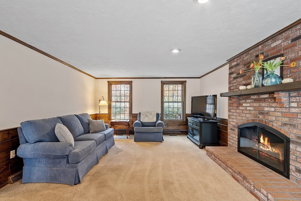 426 River Road Andover, MA 01810 - Photo 16 of 42 a living room with furniture a fireplace and a flat screen tv