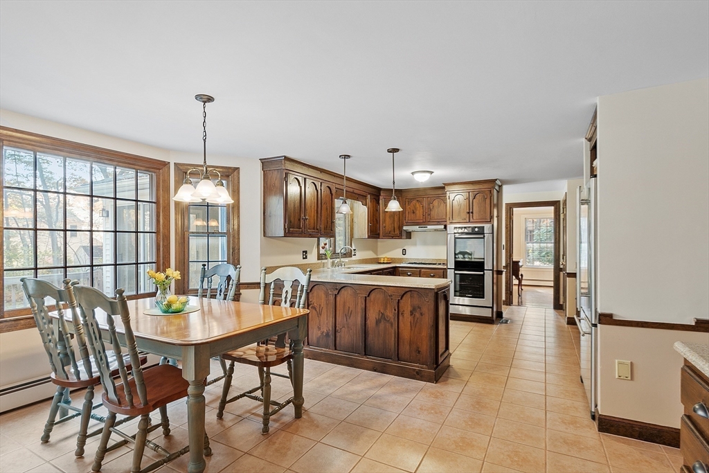 426 River Road Andover, MA 01810 - Photo 9 of 42 a kitchen with stainless steel appliances kitchen island granite countertop a table chairs and a refrigerator