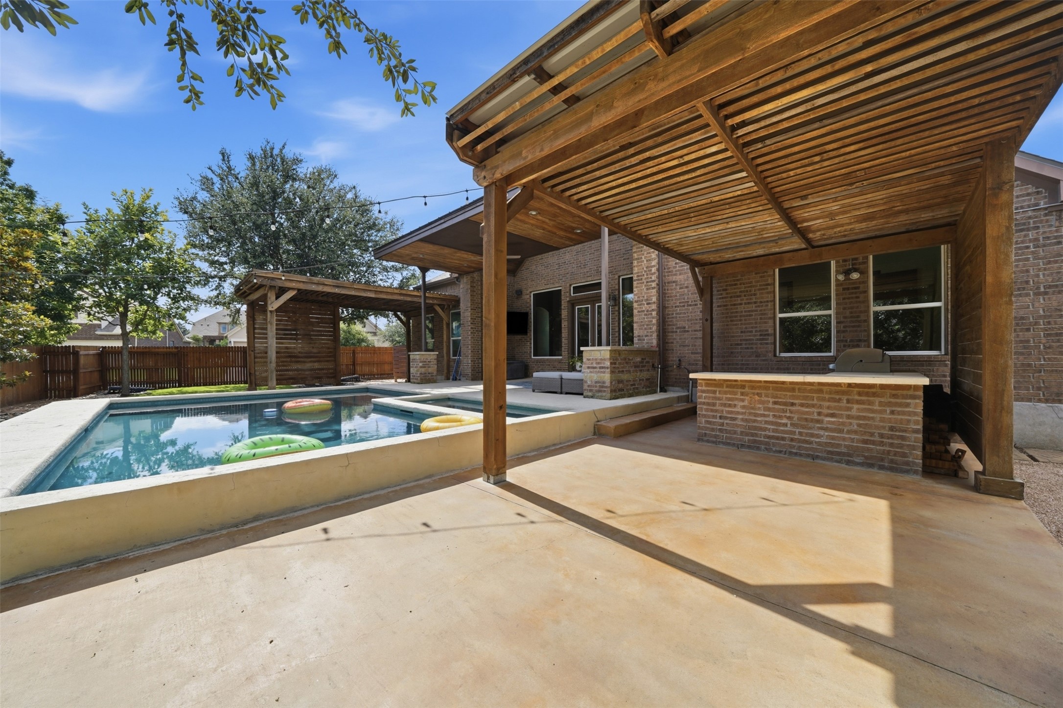 8729 Vantage Point Drive Austin, TX 78737 - Photo 27 of 33 An inviting backyard oasis offers a sparkling pool and a covered outdoor kitchen, perfect for entertaining.