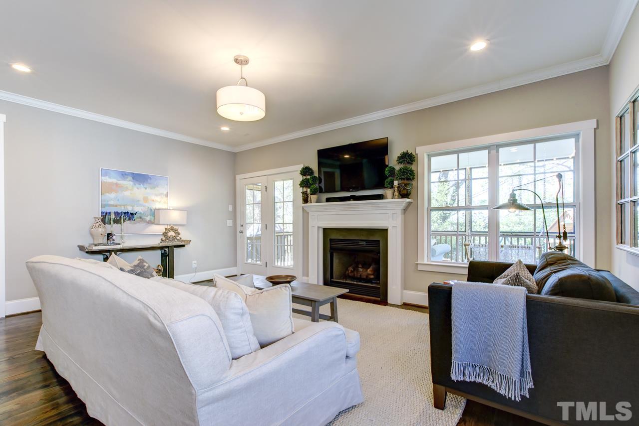 1711 Center Road Raleigh, NC 27608 - Photo 3 of 25 a living room with furniture fireplace and a flat screen tv