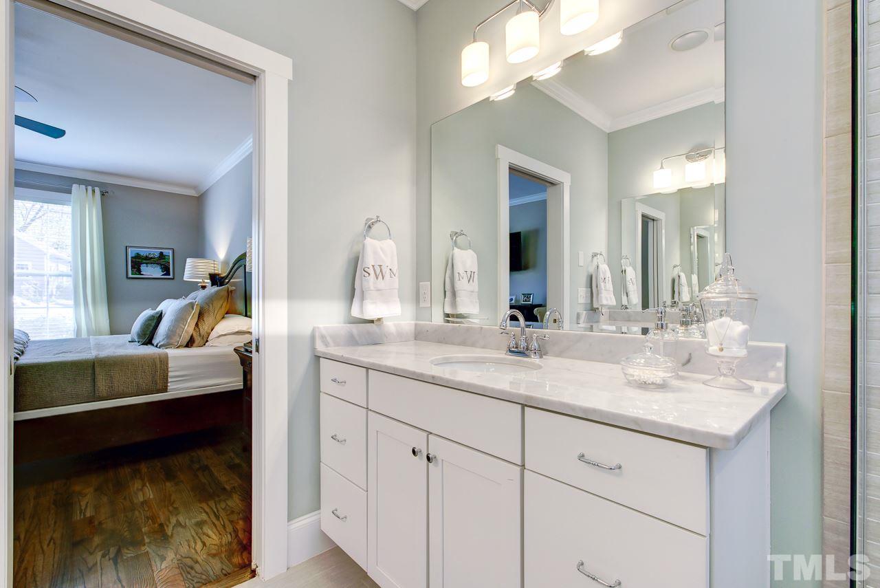 1711 Center Road Raleigh, NC 27608 - Photo 10 of 25 a en suite bathroom with a granite countertop sink and a mirror