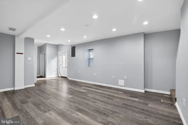 a view of an empty room with wooden floor