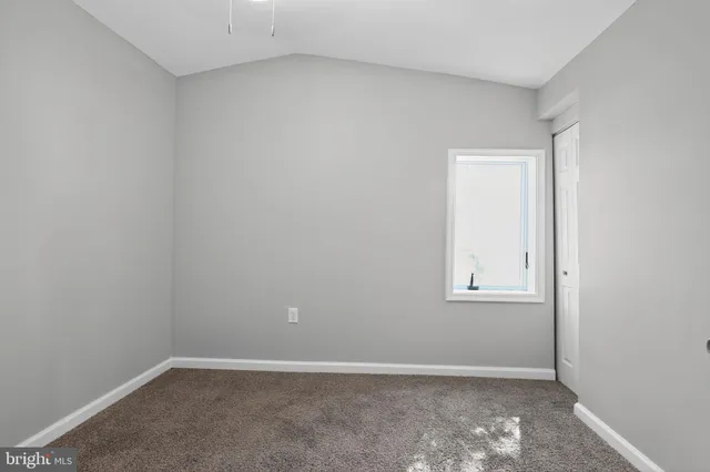 an empty room with white wall and a window
