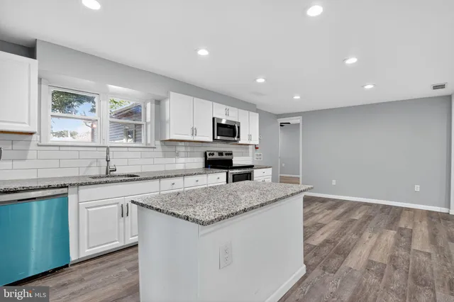 a kitchen with granite countertop a sink and steel appliances