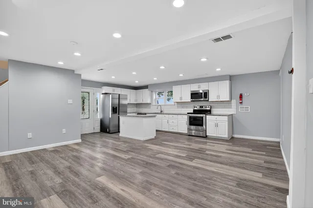 a view of kitchen with granite countertop stainless steel appliances refrigerator and center island
