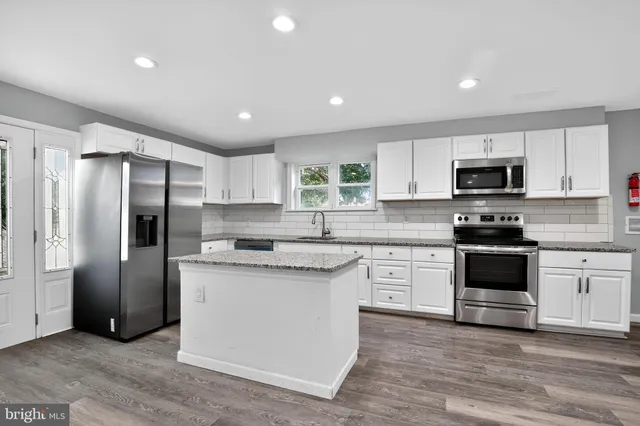 a kitchen with stainless steel appliances granite countertop a refrigerator stove microwave and sink