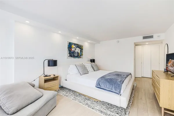 a bedroom with a bed a couch and dresser