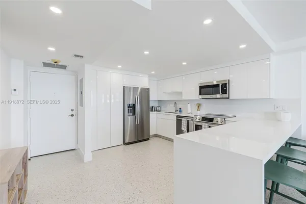 a kitchen with stainless steel appliances a refrigerator stove microwave and cabinets