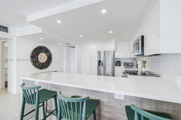 a kitchen with a table chairs a refrigerator a stove a dining table and chairs