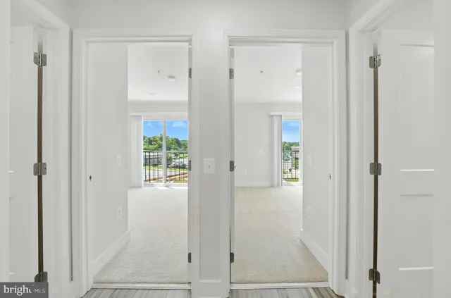 a view of a hallway with wooden floor and closet area