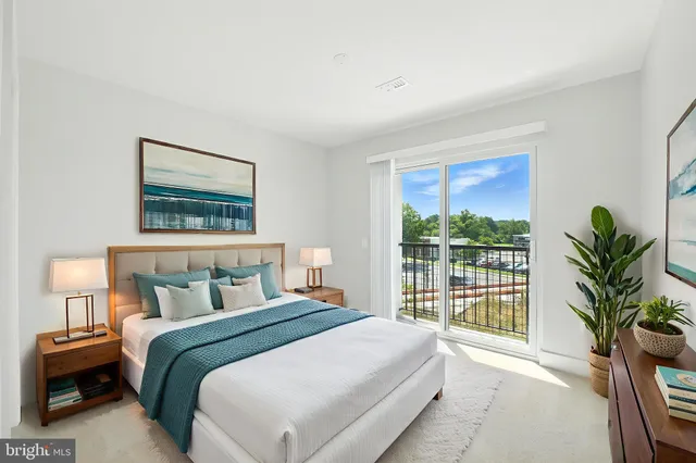 a bedroom with a large bed and a potted plant