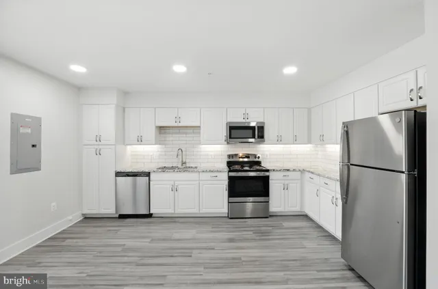 a kitchen with stainless steel appliances a refrigerator sink and stove