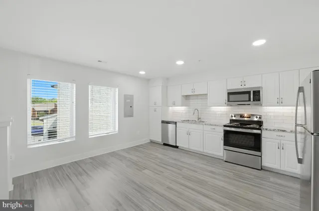 a kitchen with stainless steel appliances granite countertop a stove a sink and a refrigerator