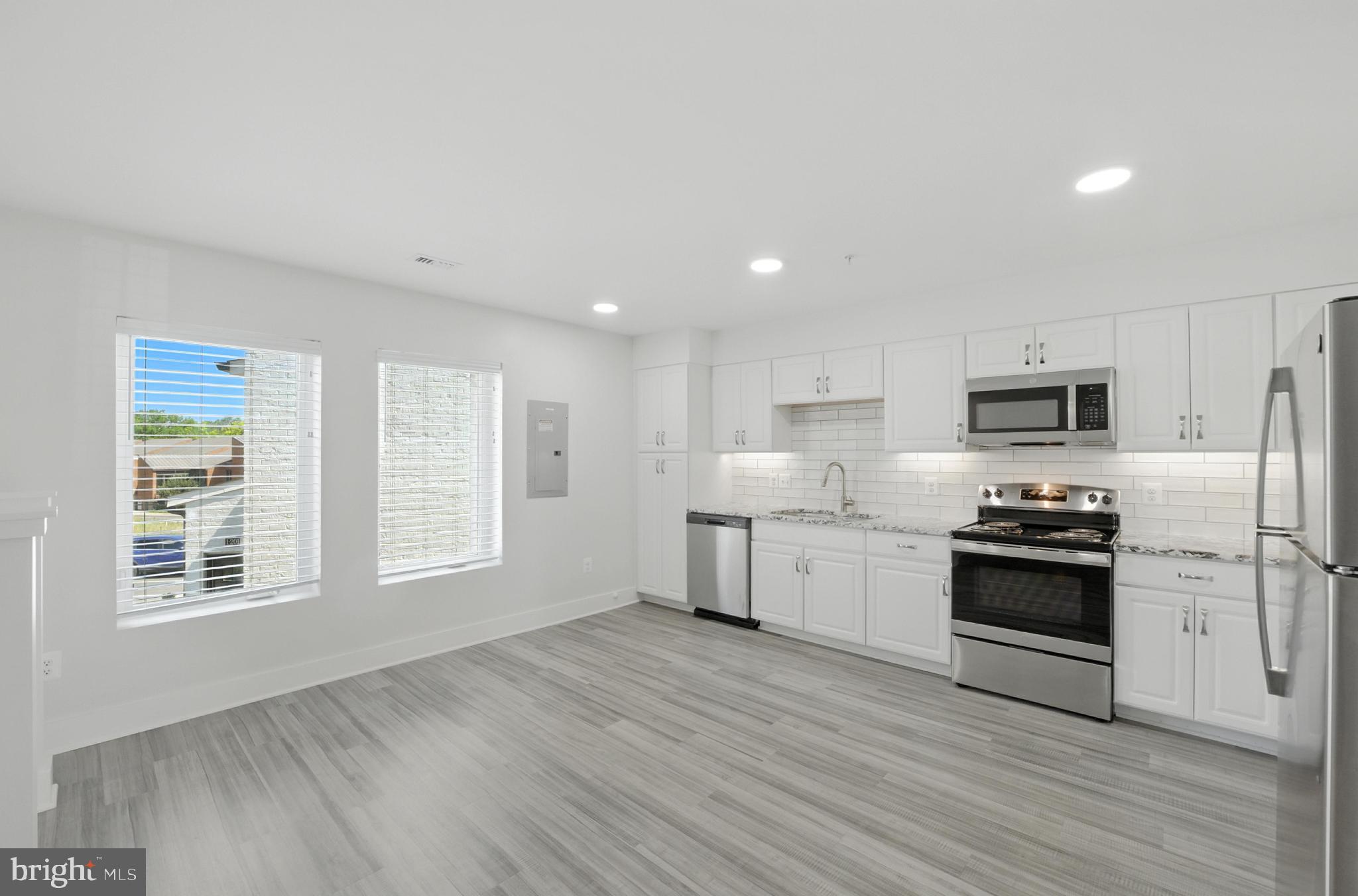 19510 Village Walk, Unit 2205 Montgomery Village, MD 20886 - Photo 7 of 21 a kitchen with stainless steel appliances granite countertop a stove a sink and a refrigerator