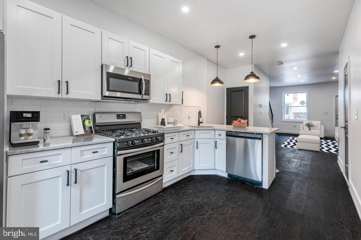 a kitchen with stainless steel appliances white cabinets sink and a stove