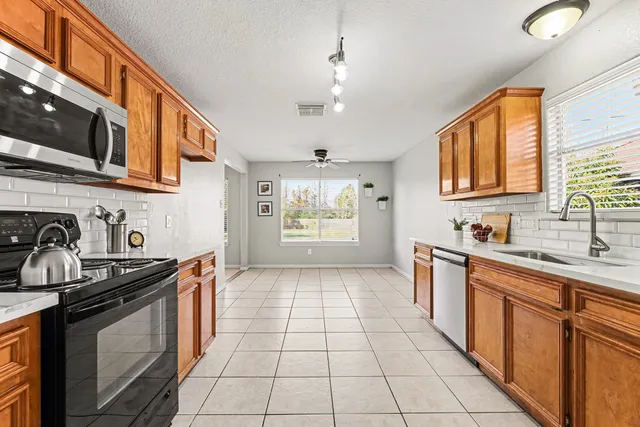 a kitchen with stainless steel appliances granite countertop a stove a sink and a microwave