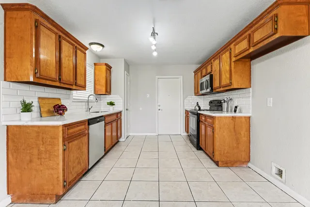 a kitchen with stainless steel appliances granite countertop a stove a sink and a refrigerator