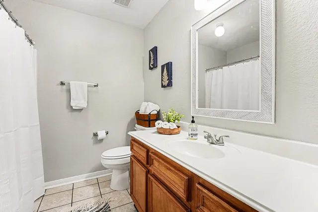 a bathroom with a sink vanity granite and toilet