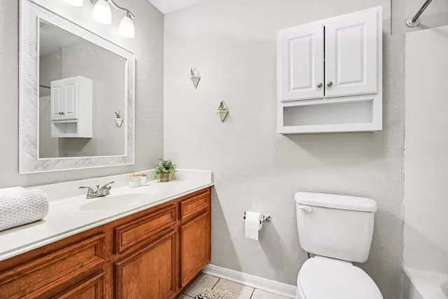 a bathroom with a toilet a sink and mirror