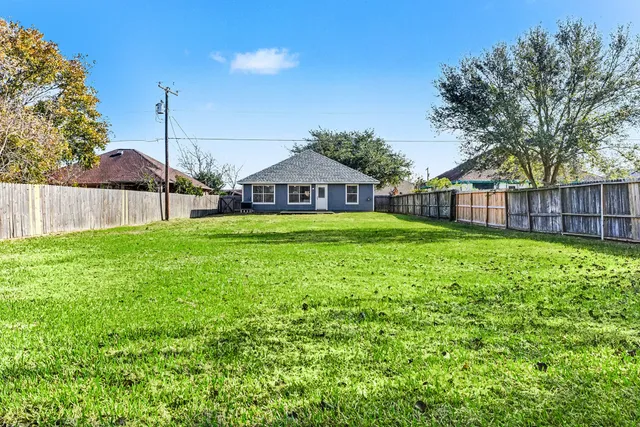 a view of a house with a big yard and large trees