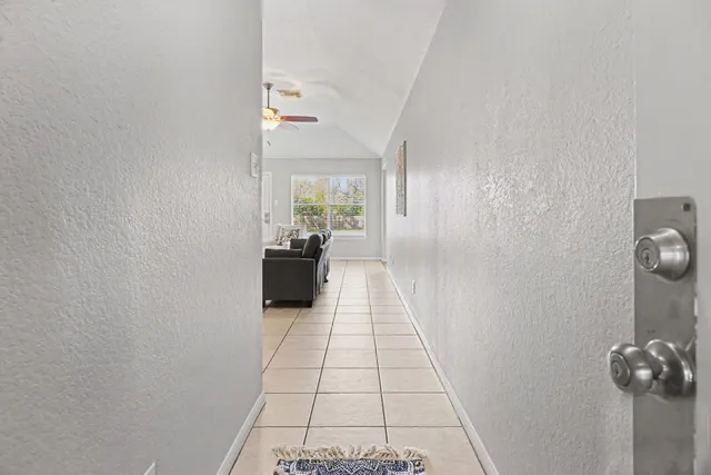 a view of a hallway to a room with windows