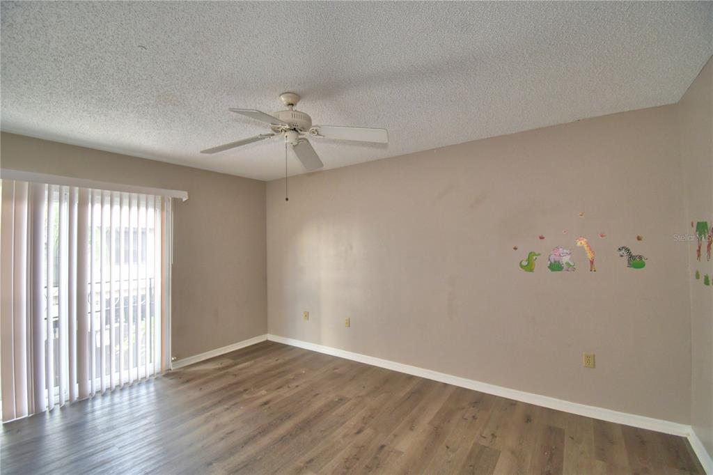 573 Hunter Circle Kissimmee, FL 34758 - Photo 23 of 36 an empty room with wooden floor and window