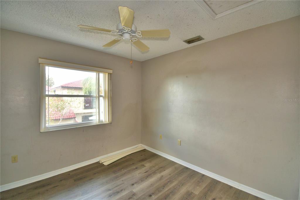 573 Hunter Circle Kissimmee, FL 34758 - Photo 27 of 36 an empty room with wooden floor fan and windows