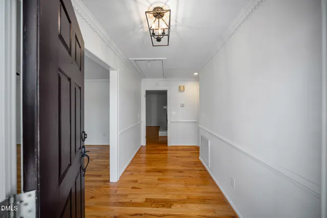 a view of a hallway with wooden floor and stairs