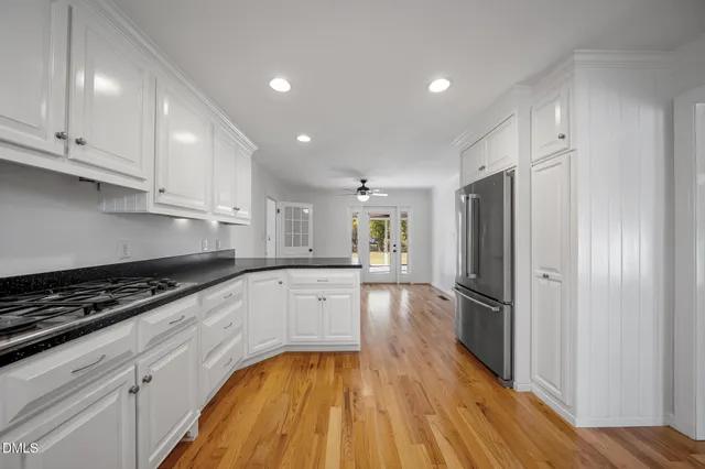 a kitchen with a refrigerator a sink and wooden cabinets