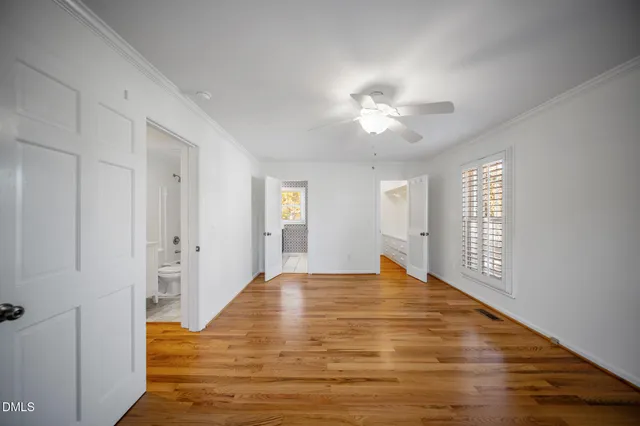 a view of empty room with window and ceiling fan