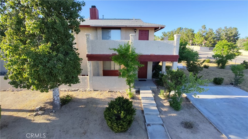 16228 Wato Road Apple Valley, CA 92307 - Photo 3 of 17 a front view of a house with a yard and a garage