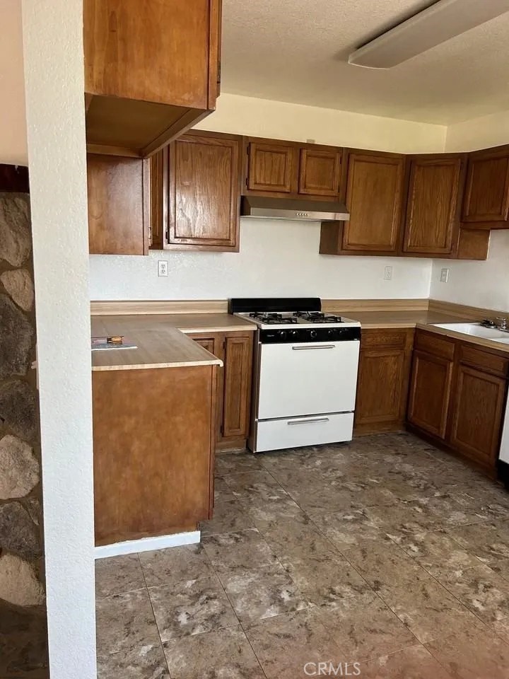 16228 Wato Road Apple Valley, CA 92307 - Photo 7 of 17 a kitchen with stainless steel appliances granite countertop a sink stove and cabinets