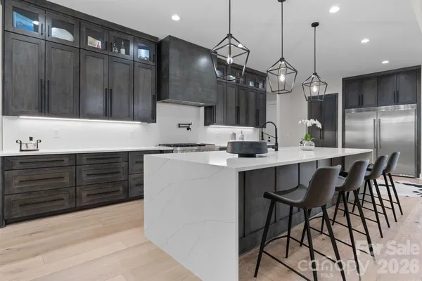 a kitchen with granite countertop a table chairs stainless steel appliances and cabinets