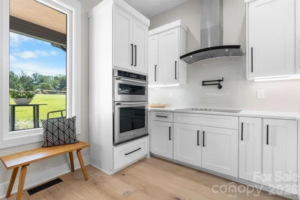 a kitchen with white cabinets and appliances