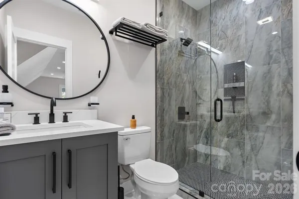 a bathroom with a sink a toilet and a mirror