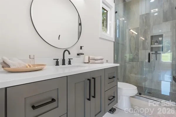 a bathroom with a double vanity sink mirror and toilet