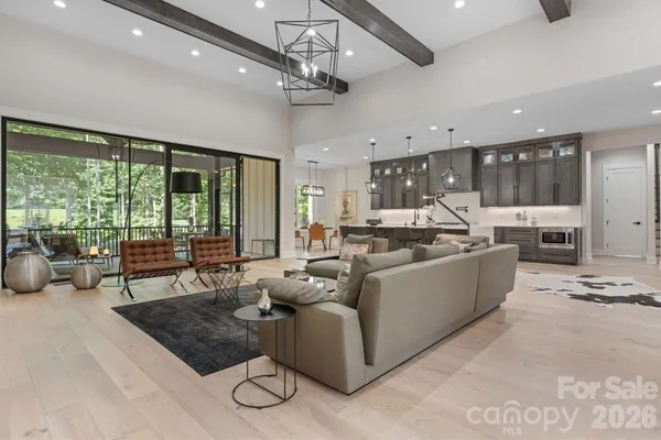 a living room with furniture and a dining table with kitchen view
