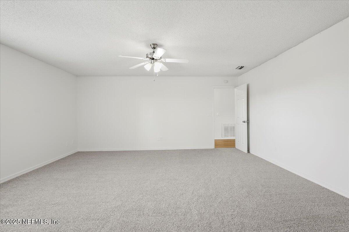 8215 Sailmaker Lane Jacksonville, FL 32210 - Photo 12 of 29 an empty room with a empty space and a ceiling fan