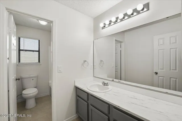 a bathroom with a toilet a sink and mirror