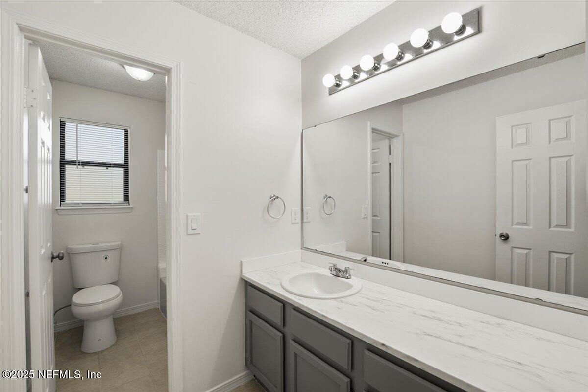 8215 Sailmaker Lane Jacksonville, FL 32210 - Photo 15 of 29 a bathroom with a toilet a sink and mirror