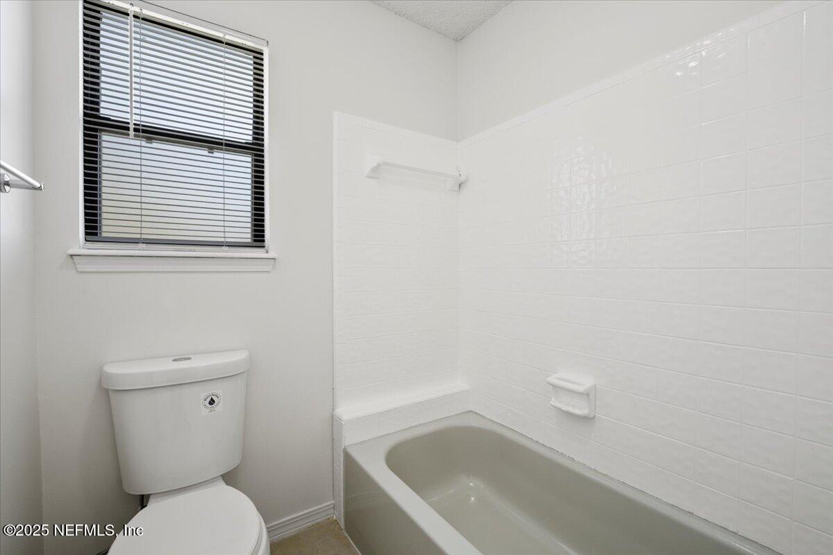 8215 Sailmaker Lane Jacksonville, FL 32210 - Photo 22 of 29 a white toilet sitting next to a bath tub
