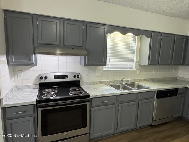 a kitchen with a sink stove and cabinets