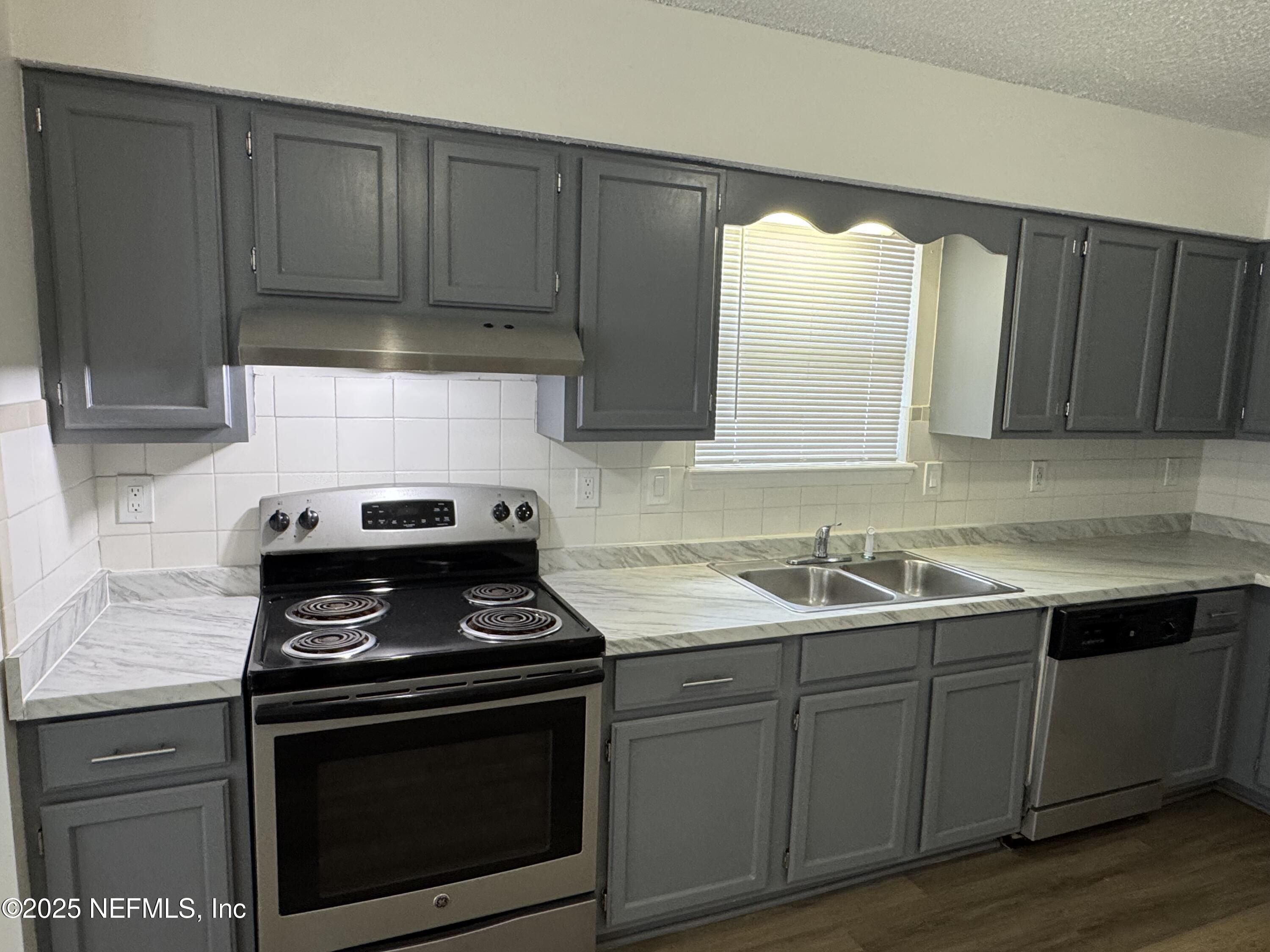 8215 Sailmaker Lane Jacksonville, FL 32210 - Photo 7 of 29 a kitchen with a sink stove and cabinets