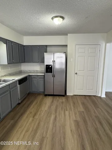 a kitchen with granite countertop a sink and stainless steel appliances