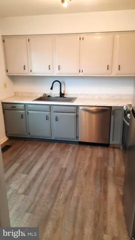 a kitchen with granite countertop white cabinets and stainless steel appliances