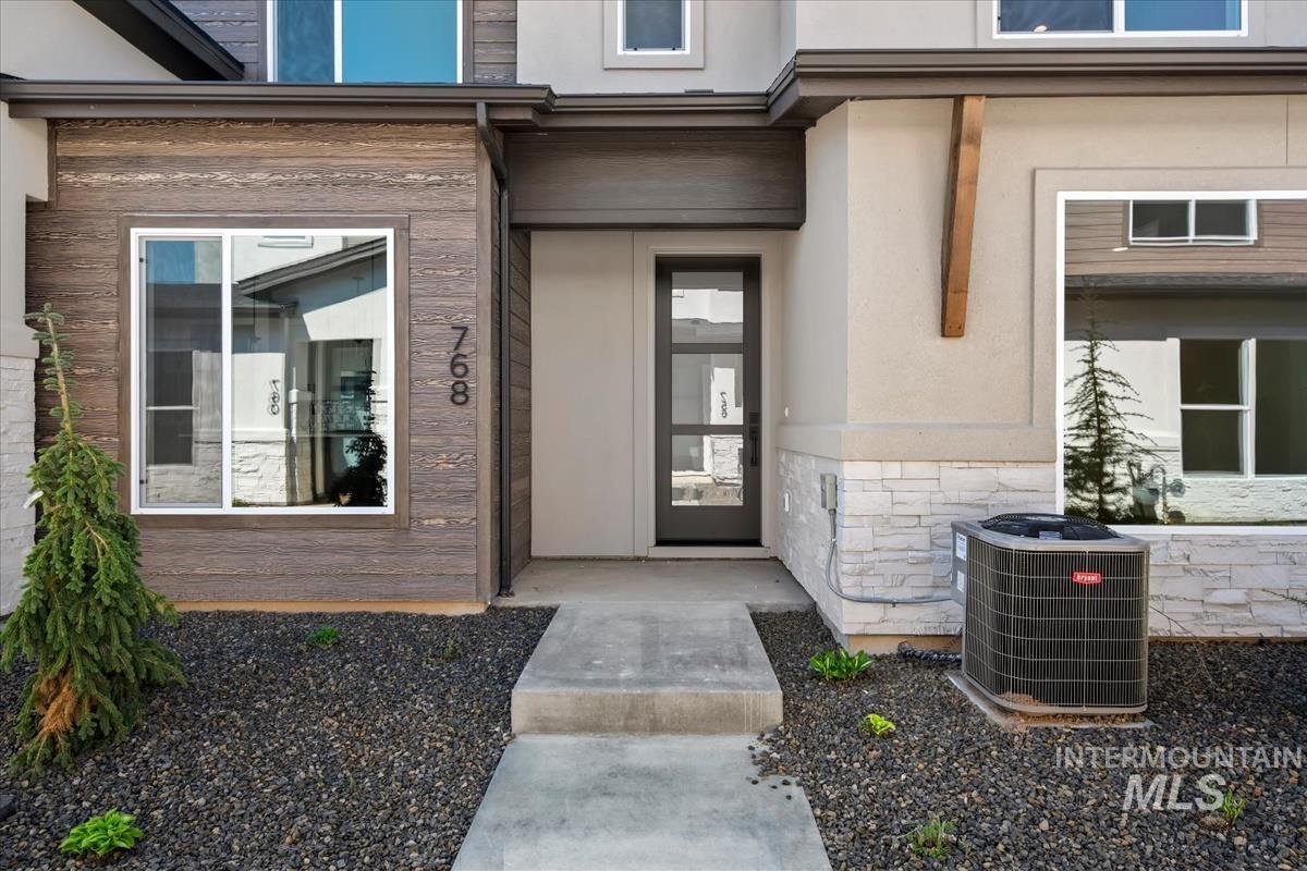 768 South Calhoun Lane Star, ID 83669 - Photo 2 of 36 Contemporary exterior featuring a modern entry door, stucco siding, and stone veneer accents